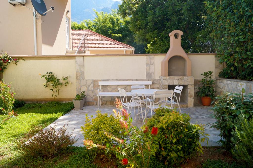 eine Terrasse mit einem Tisch und Stühlen im Garten in der Unterkunft Veron Apartments in Kotor
