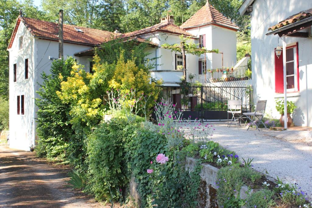 un jardin avec des fleurs en face d'une maison dans l'établissement Castel Rouge, à Luzech