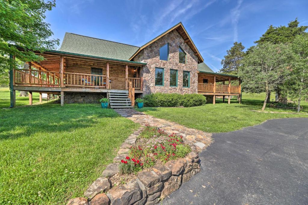a log home with a porch and a deck at Eureka Springs Area Cabin with Deck and 7 Acres! in Golden