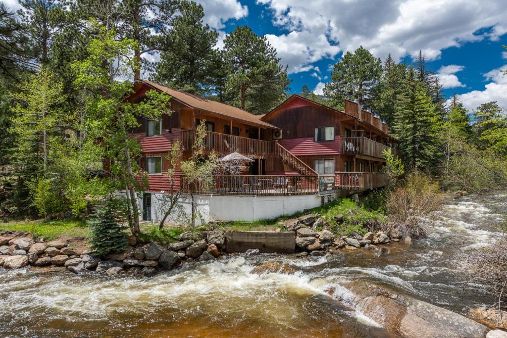 a house on a river in the woods at Ponderosa Lodge in Estes Park