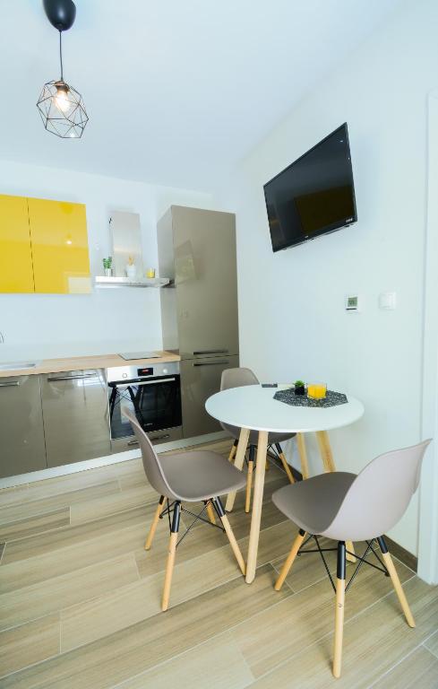 kuchnia ze stołem i krzesłami oraz telewizorem w obiekcie Apartment Grey&Yellow w mieście Zadar