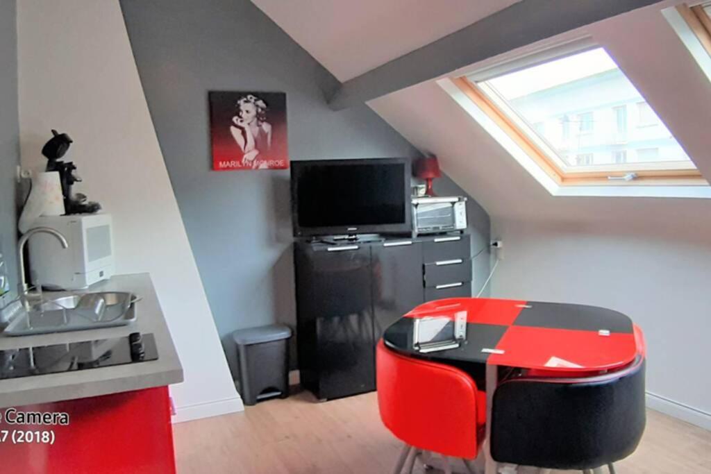 un salon avec une chaise rouge et une table dans l'établissement Centre mer, à Saint-Valery-en-Caux