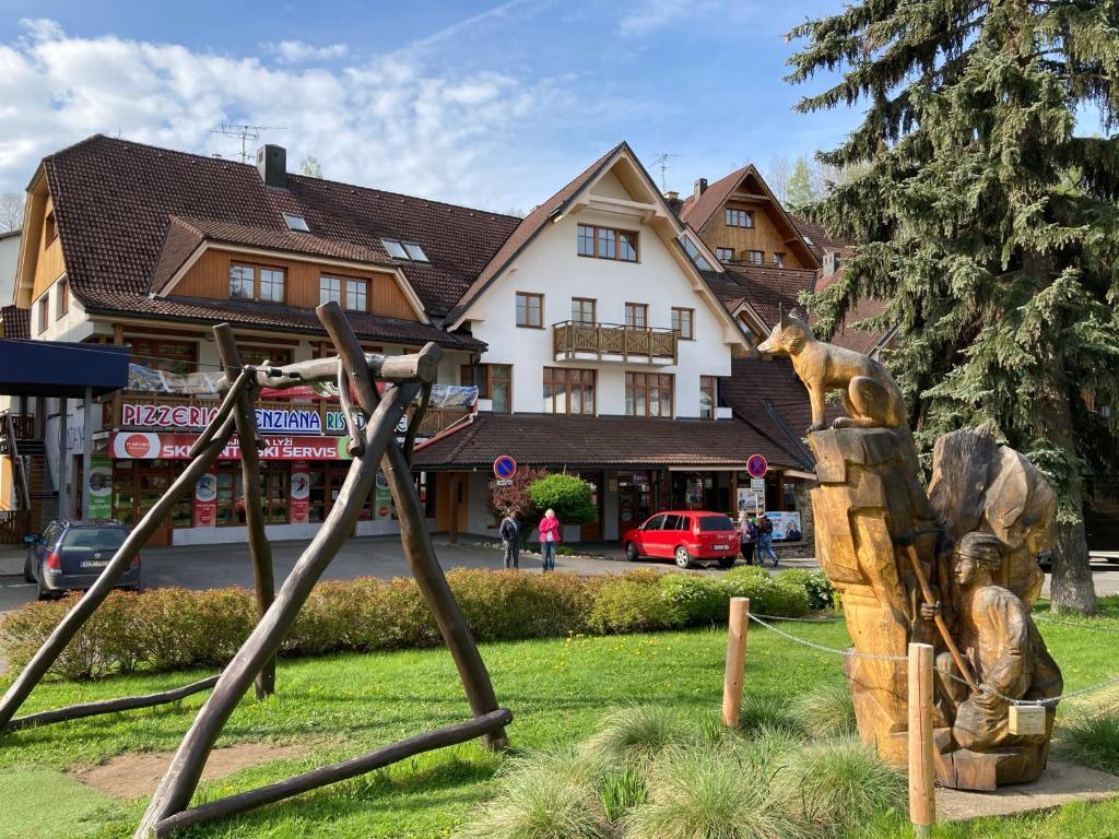 a statue of a bear on a swing at Dolní Náměstí in Rokytnice nad Jizerou