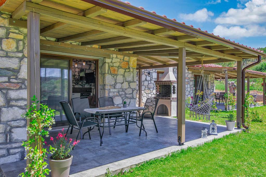 a wooden pergola with a table and chairs on a patio at White Stone Villas Dimitra and Eleni in Agios Nikolaos