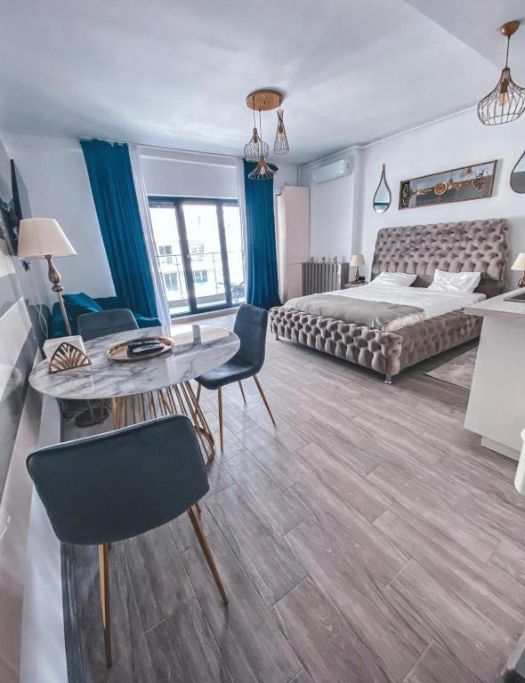 a bedroom with a bed and a table and chairs at Mamaia Luxury Studio Apartment T in Mamaia