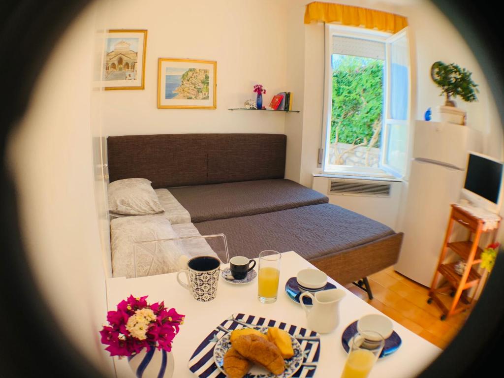 Habitación pequeña con cama y mesa con comida en L'Angolo di Felicia, en Nerano