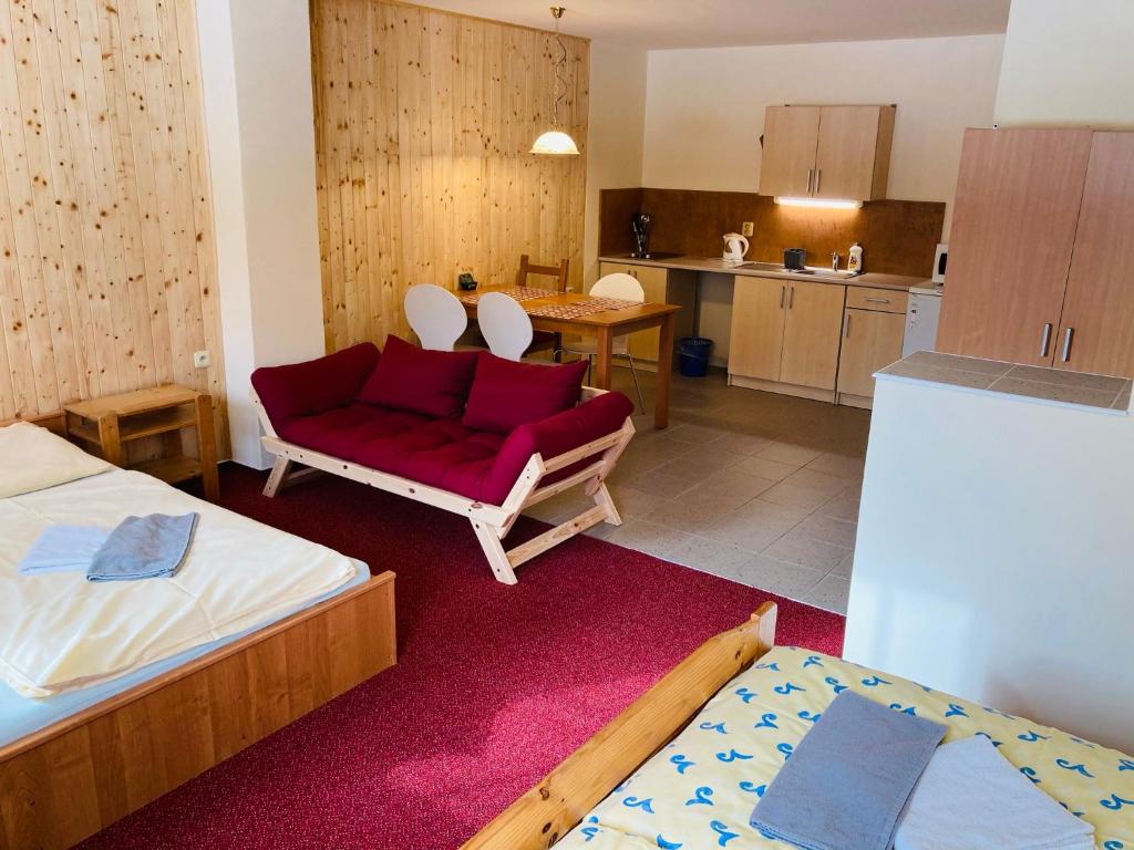 a living room with two beds and a red couch at Studia Pod Lysou in Rokytnice nad Jizerou