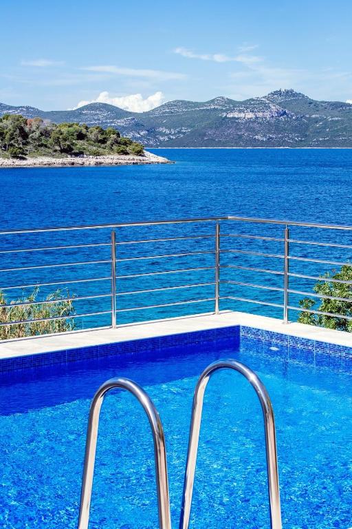 a swimming pool with a view of the water at Holiday Home Malinina in Mali Iž