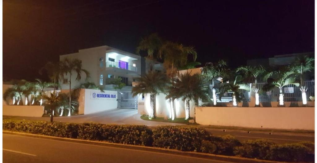 a building with palm trees in front of a street at Furnished Apartment - Residencial Olas - Gated Community - 24 hr Security in San Felipe de Puerto Plata