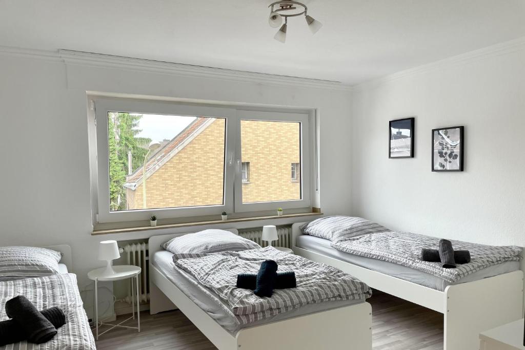 two beds in a room with a window at Schöne 3 Zimmerwohnung in Düren in Düren - Eifel