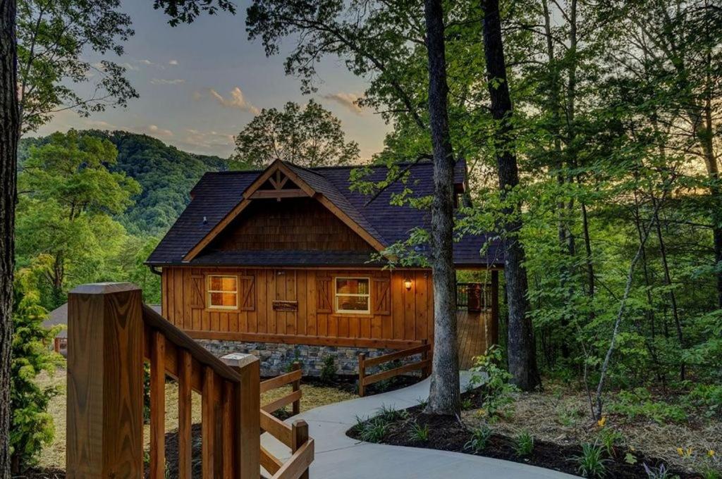 eine Blockhütte im Wald mit einem Holzzaun in der Unterkunft A Cozy Mountain Hideaway - 1 Bedrooms, 1 Baths, Sleeps 4 cabin in Sevierville