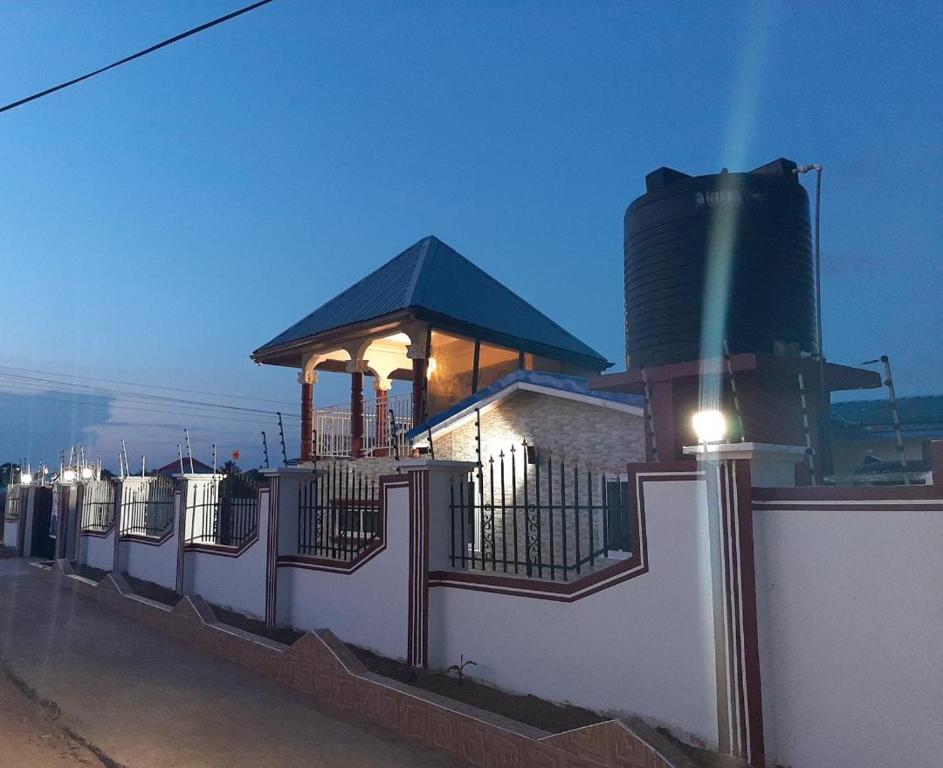 Ein Gebäude mit einem Zaun und einem Silo drauf. in der Unterkunft MAXJEN HAVEN GUEST HOUSE in Kasoa