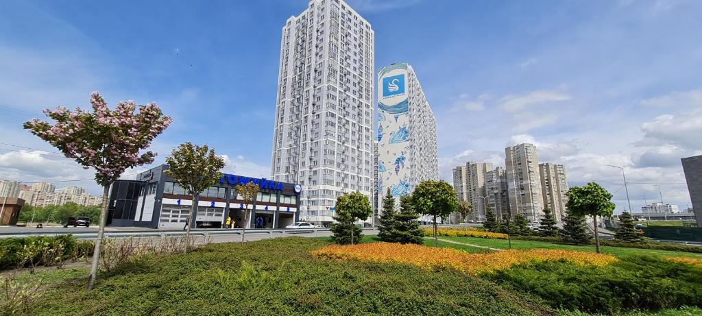 - un grand bâtiment blanc avec un panneau devant dans l'établissement Apartments Swan Lake, à Kiev