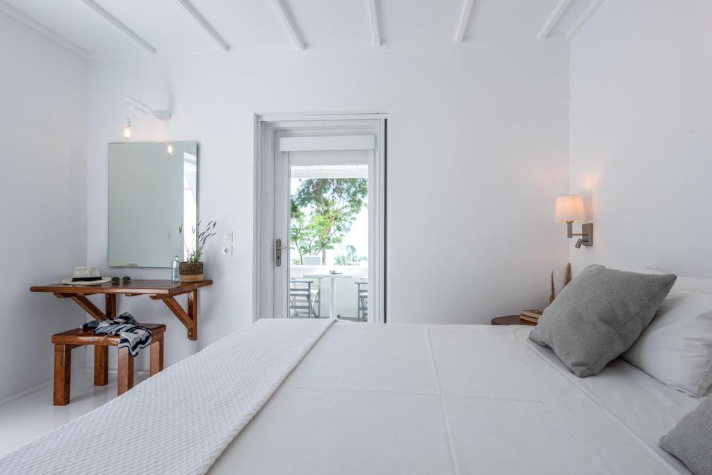 カテリオスにあるCasa Montzo boutique hotelの白いベッドルーム(大型ベッド1台、テーブル付)