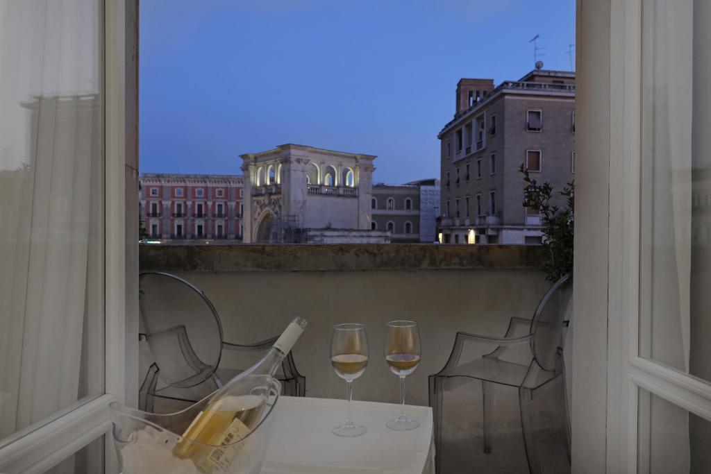 Luxury House Lecce -Le mie 3 Suites- في ليتشي: طاولة مع كأسين من النبيذ على شرفة