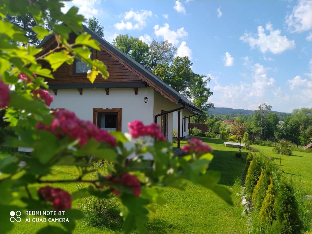 ein Cottage mit einem Garten und Blumen in der Unterkunft Na Szlaku - domki do wynajęcia in Rabka-Zdrój