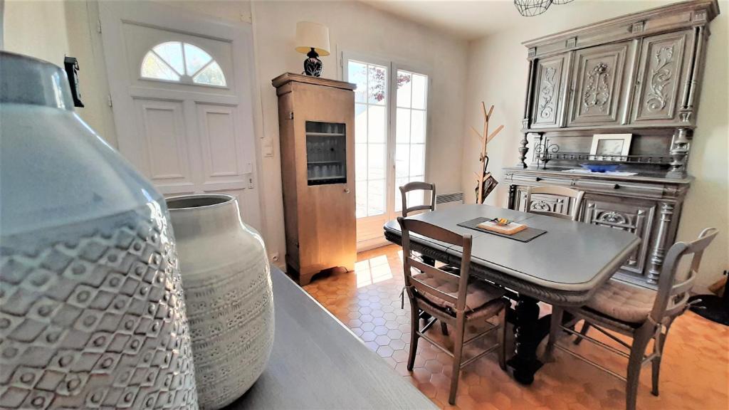 un salon avec une table et une cuisine dans l'établissement Charmante maison de ville avec jardin - 2 chambres - 5 pers, à Saint-Jean-de-Monts