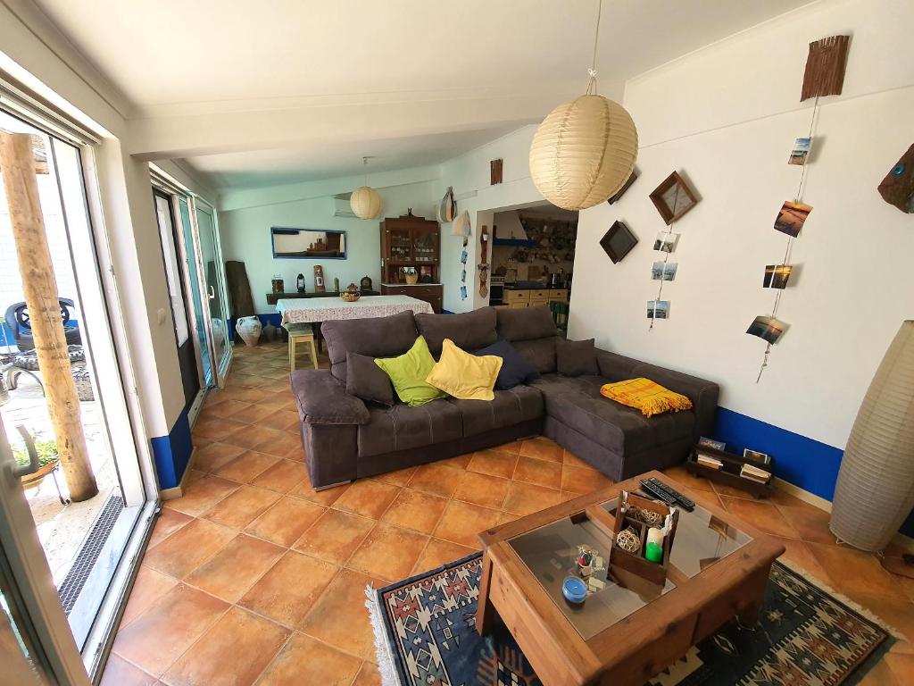 uma sala de estar com um sofá e uma mesa em Comporta Family House na Comporta