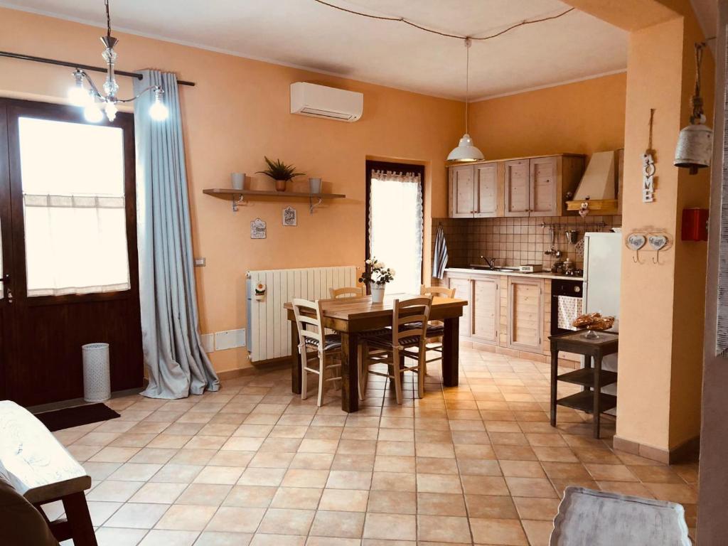 B&B La Lumachella في Porano: مطبخ مع طاولة خشبية وغرفة طعام