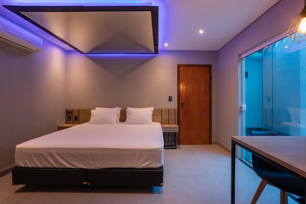 a bedroom with a bed with a purple lighting at Drops Motel São José do Rio Preto in Sao Jose do Rio Preto