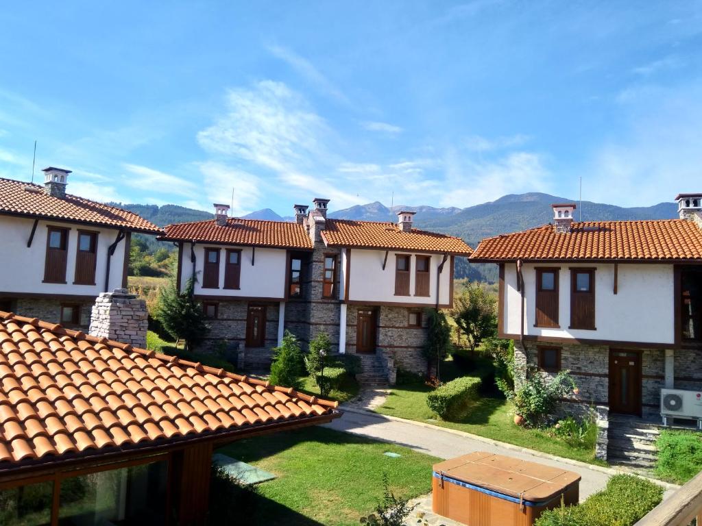 a row of houses with mountains in the background at Вила Магдалена, к-с Александриа in Dobrinishte