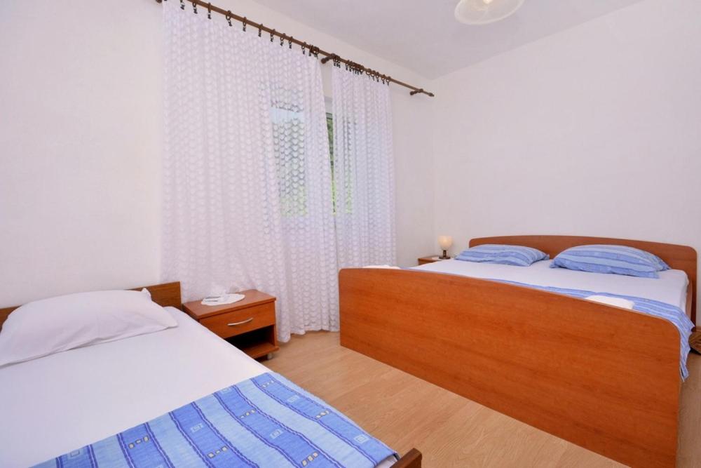 a bedroom with two beds and a window at One bedroom apartment 3558-5 in Žuljana