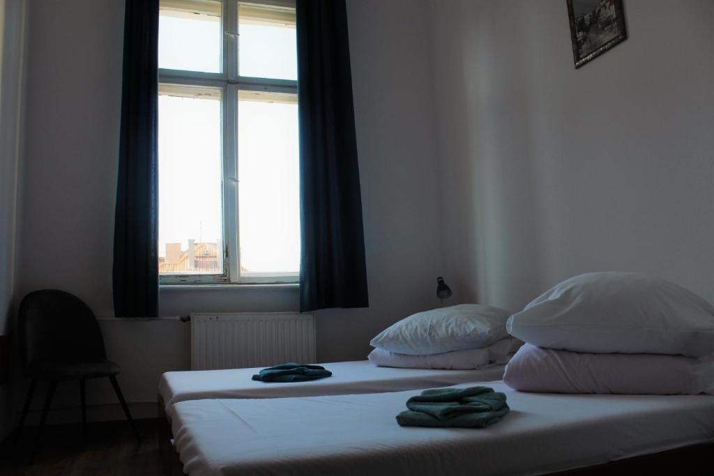 1 dormitorio con 1 cama con 2 almohadas y ventana en Galeona, en Elbląg