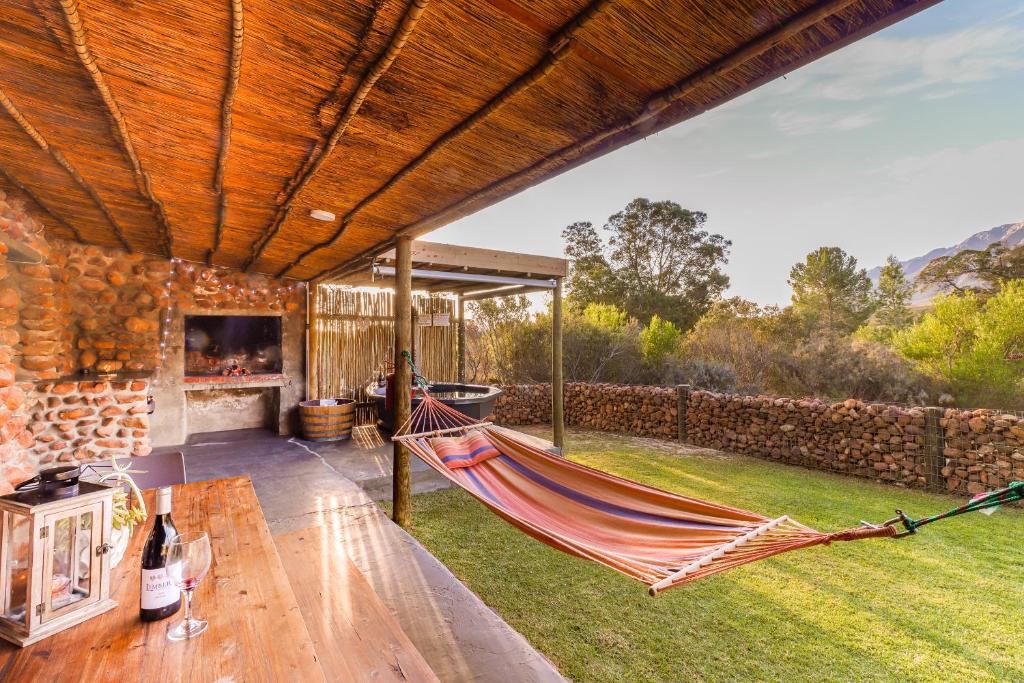 - un hamac dans l'arrière-cour d'une maison dans l'établissement Steenbok farm cottages Aalwyn Cottage, à Wolseley