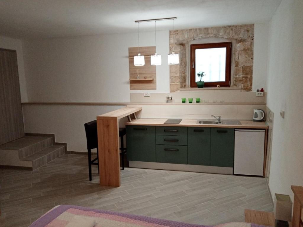 una cocina con armarios verdes y fregadero en Studio apartment Iva, en Bale