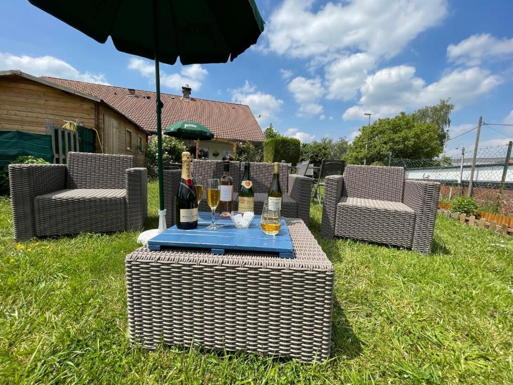 a table with wine glasses and an umbrella at Kyriad Cambrai in Cambrai