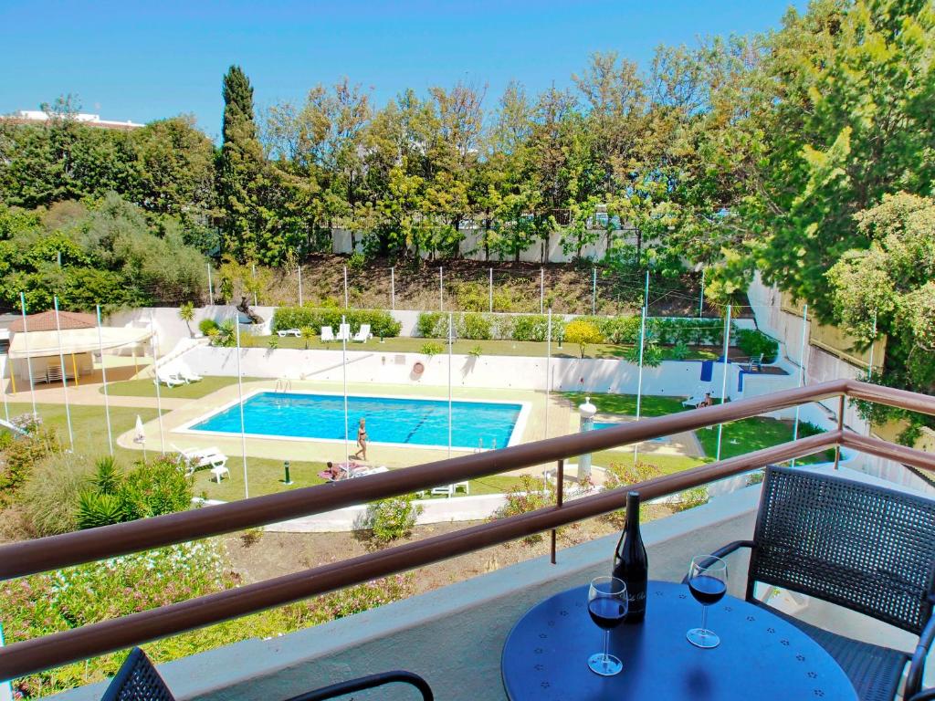 uma varanda com uma mesa e vista para uma piscina em Casa Nikolina em Albufeira