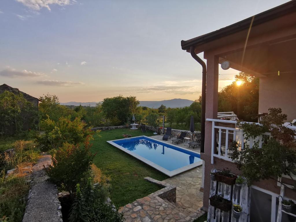 a backyard with a swimming pool and a house at Apartman Selma in Vinine