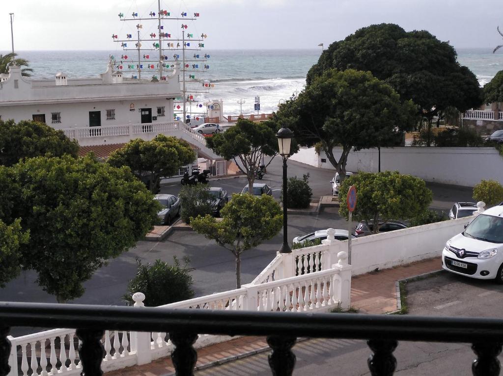widok na ulicę z białym płotem i ocean w obiekcie Pueblo Quinta w mieście Benalmádena