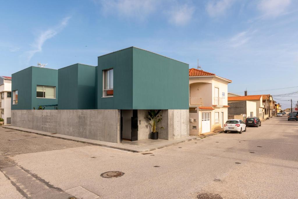 a house with a green roof on a street at Casa d´Avó Dalina in Figueira da Foz