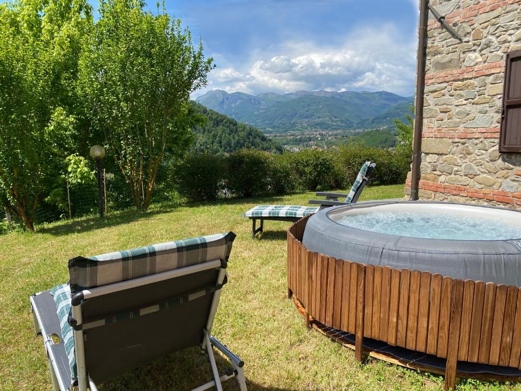 una bañera de hidromasaje en el patio trasero de una casa en Cottage House Il Palazzetto en Castelnuovo di Garfagnana