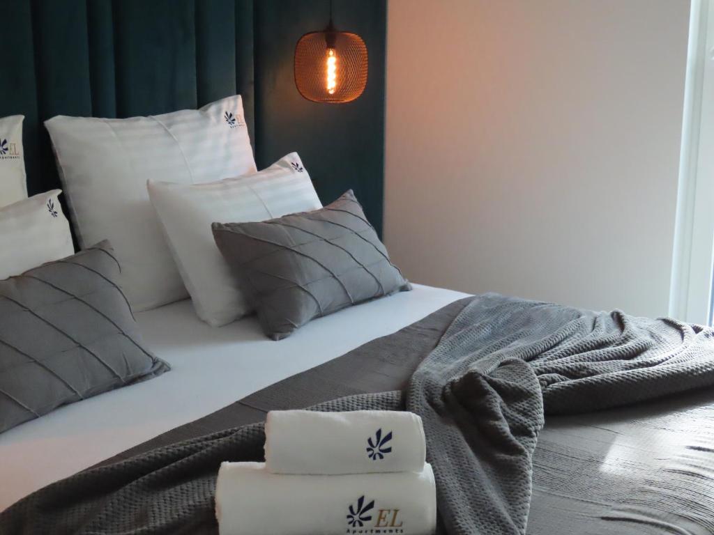 Una cama con almohadas y una manta. en EL Apartments - Polaris, en Poznan