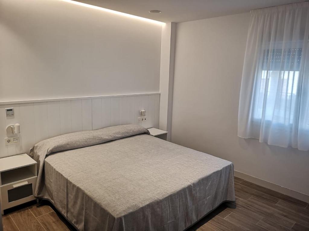 a small bedroom with a bed and a window at Casa Raquel,caminito del Rey in Valle de Abdalagís