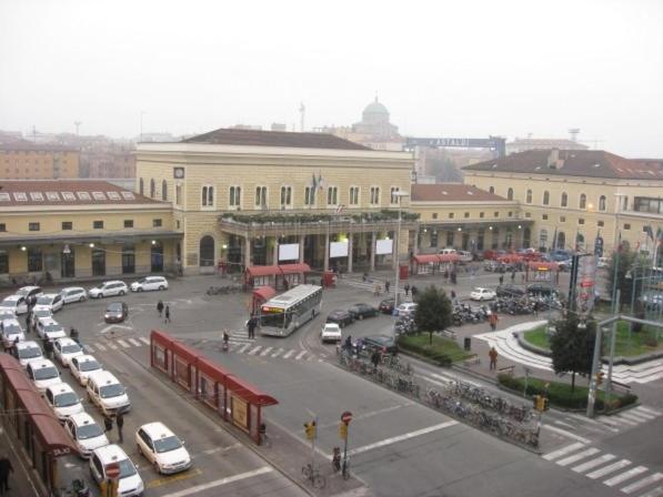 a city street with cars parked in front of a building at Bologna Bed Station in Bologna
