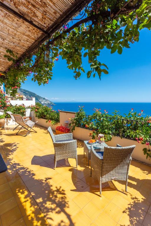 a patio with chairs and a table with a view of the ocean at il Pettirosso in Positano in Positano