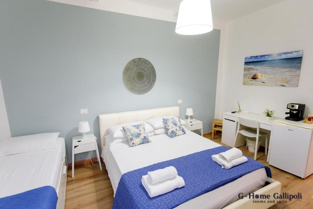 G-Home Gallipoli rooms and suite في غالّيبولي: غرفة نوم بها سرير وطاولة ومكتب