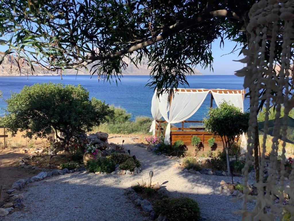 a tent on the beach with the ocean in the background at Sylvia's houses in Kalymnos