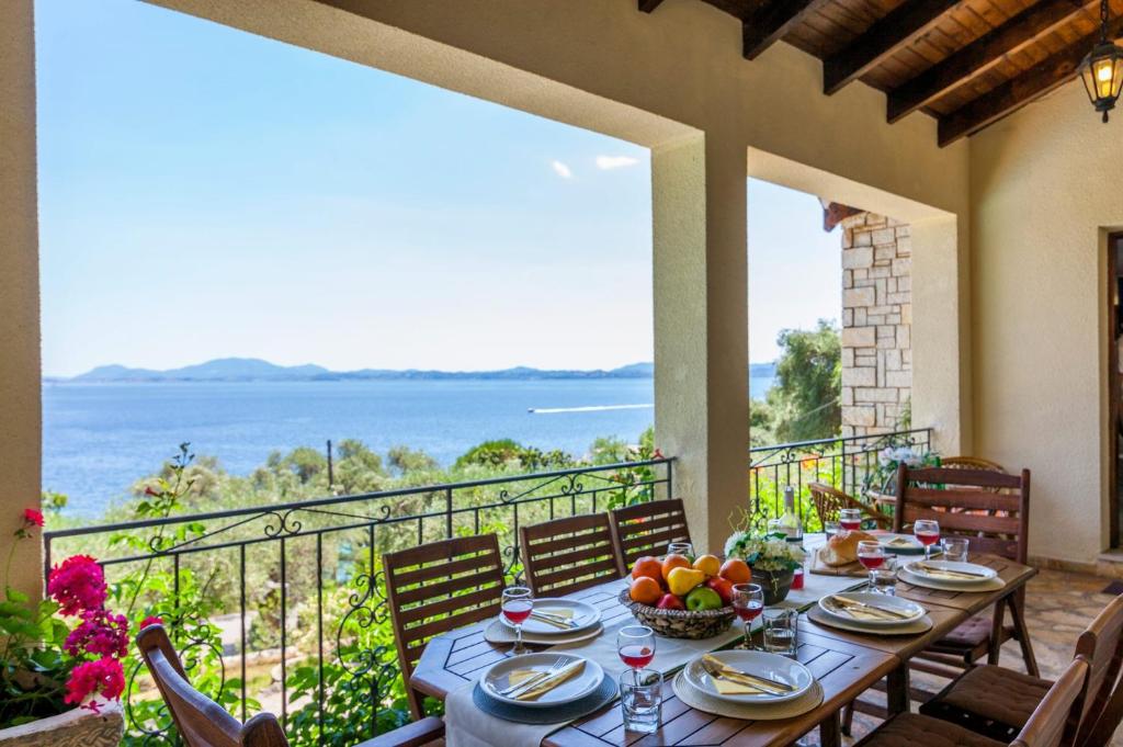 una mesa en un balcón con vistas al océano en Villa Irini Nissaki Corfu Beach Villa en Nisaki