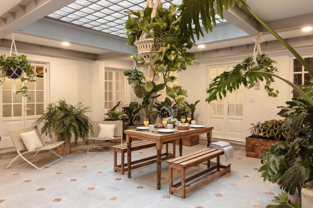 um quarto com uma mesa e um monte de plantas em Jardín Roma By The Local Way em Cidade do México