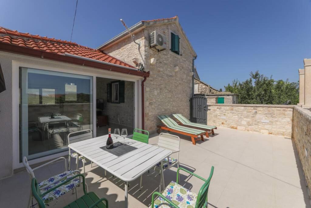 a patio with a table and chairs and a building at Kuća za odmor Mihaela in Sutivan