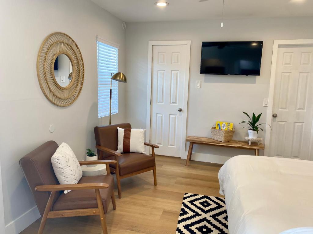 a bedroom with a bed and a chair and a tv at Steps To The Beach, Pacific City and Main Street - Studio in Huntington Beach