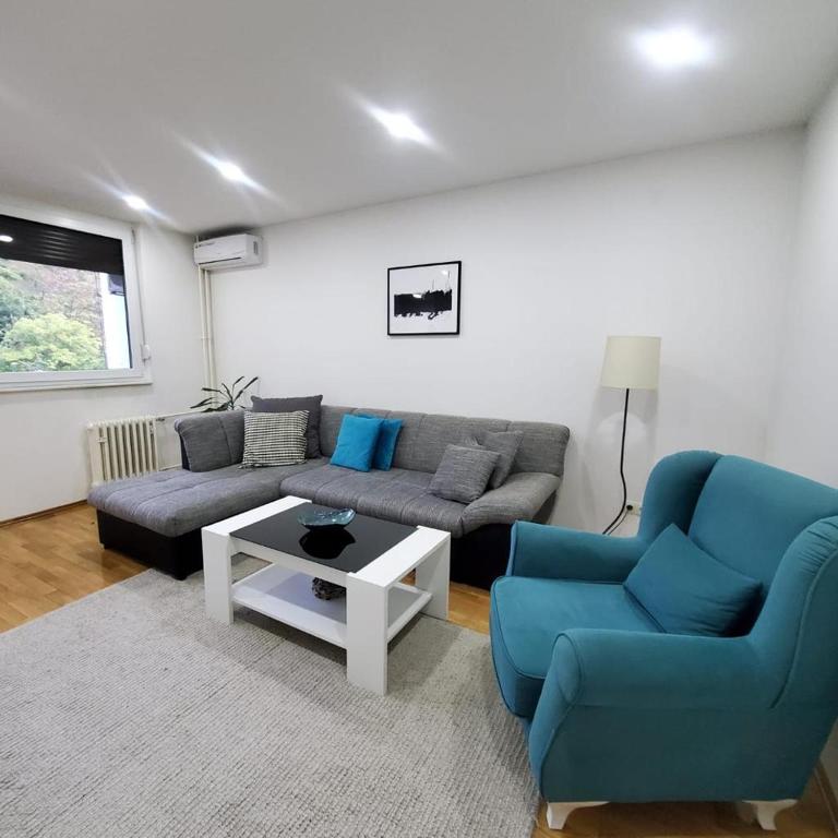sala de estar con 2 sillas azules y sofá en Ozzy, en Travnik