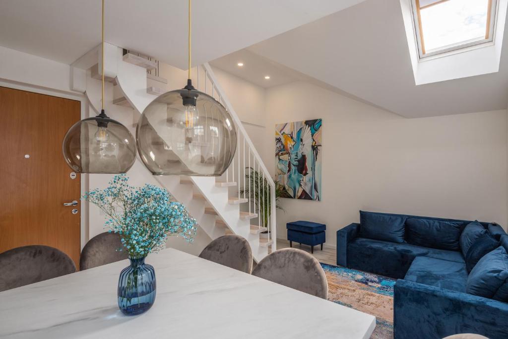 a living room with a table and a blue couch at Gerika guest house in Palanga