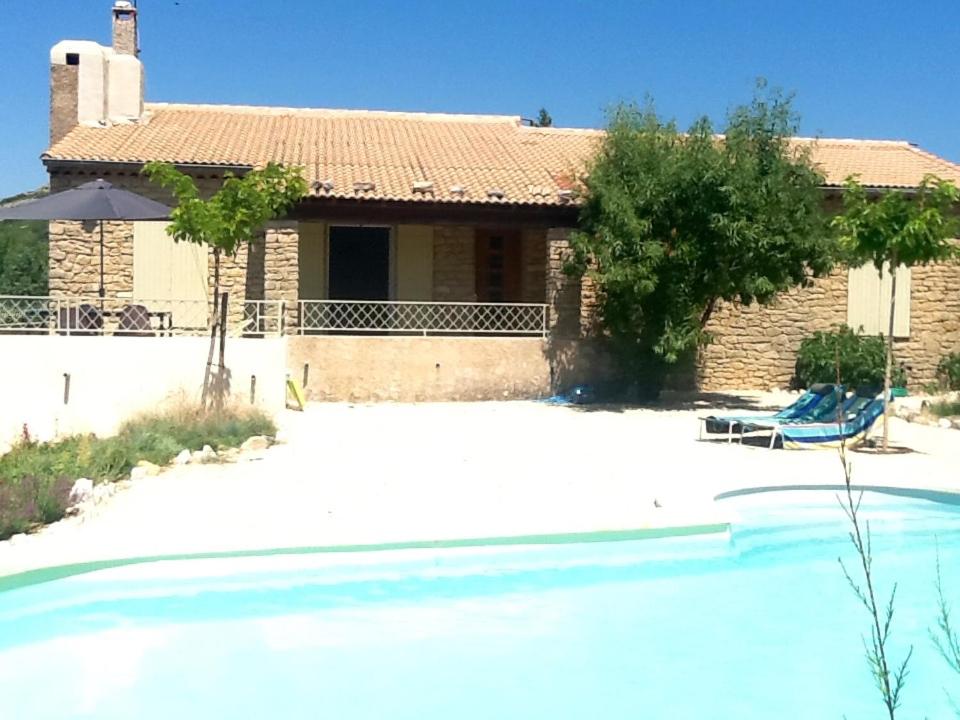 a villa with a swimming pool in front of a house at Le temps des cerises in Méthamis