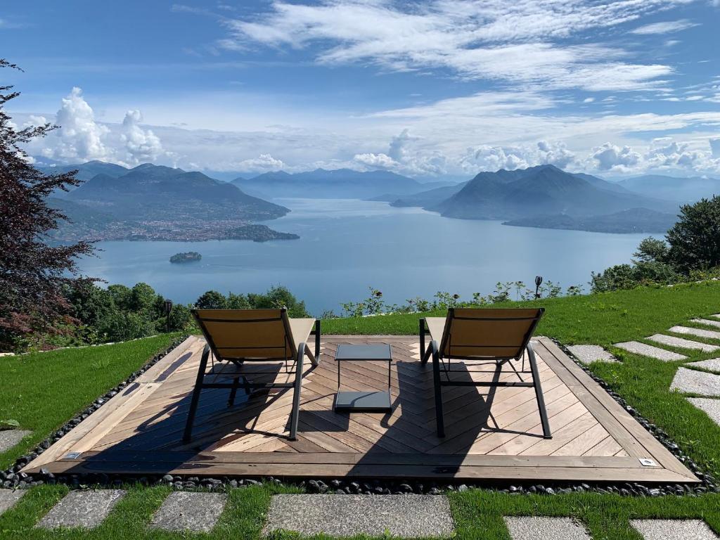 - deux chaises sur une terrasse avec vue sur le lac dans l'établissement Private Luxury Spa & Silence Retreat with Spectacular View over the Lake Maggiore, à Stresa
