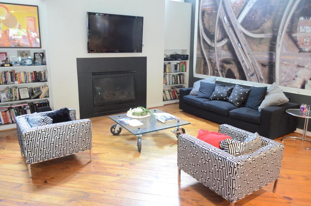 a living room with a couch and chairs and a fireplace at Modern B & B in Houston